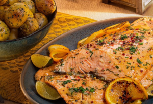Нежный запеченный лосось под соусом “ цитрусовое трио” с розовым перцем и беби-картофелем со сливочным маслом, ароматным чесноком и зеленью